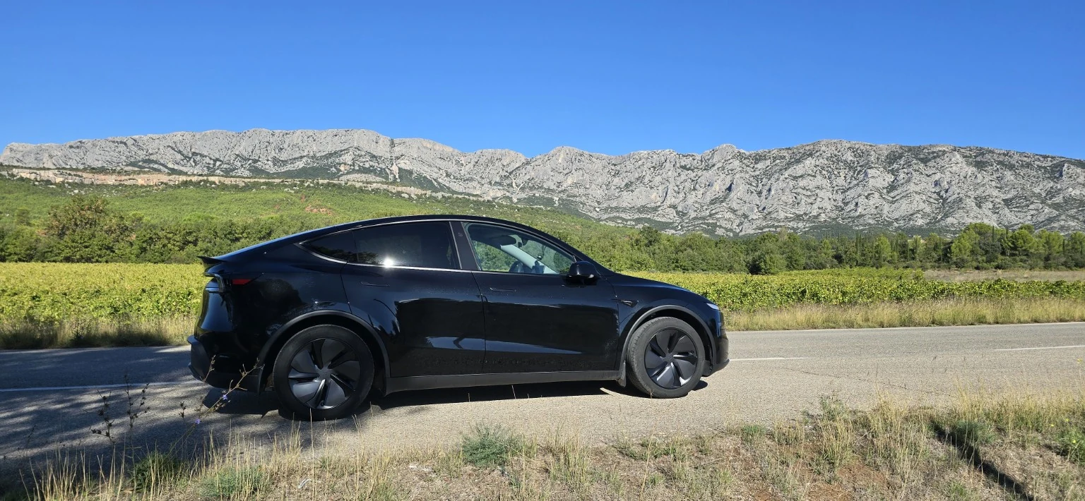 La Tesla Model Y noire de LAST SMILE vue de profil dans les paysages provençaux